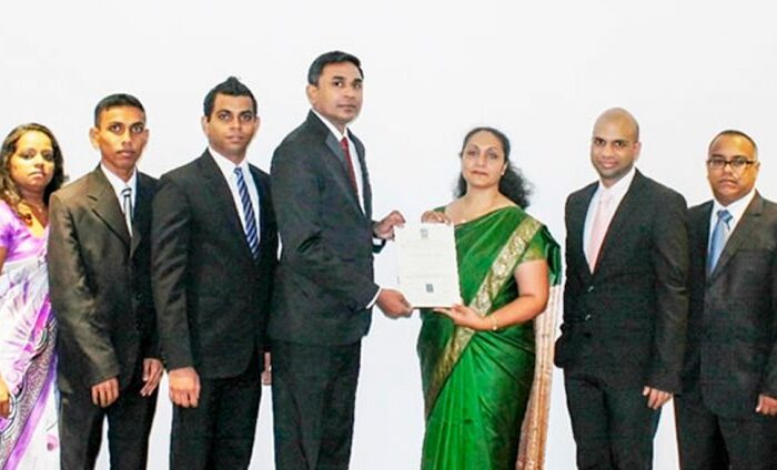 Business professionals stand with certificate.