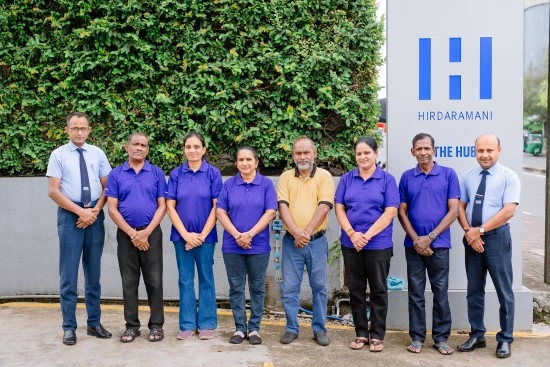 Seven employees standing in front of building.
